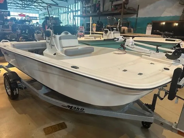 Slide: The Image of 2025 Mako Pro Skiff 13 CC boat displayed in a showroom on a trailer. - 2