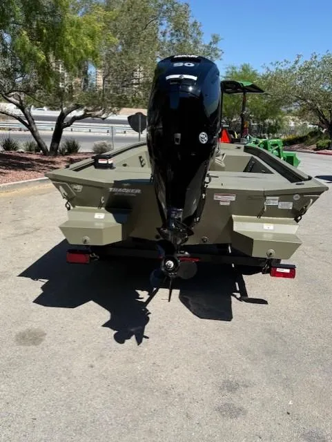 Slide: The Image of 2025 Tracker Grizzly 1860 CC boat with powerful outboard motor, parked outdoors. - 2