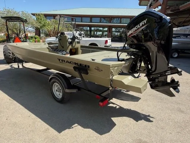 Slide: The Image of 2025 Tracker Grizzly 1860 CC boat with Mercury engine on trailer, parked outdoors. - 3