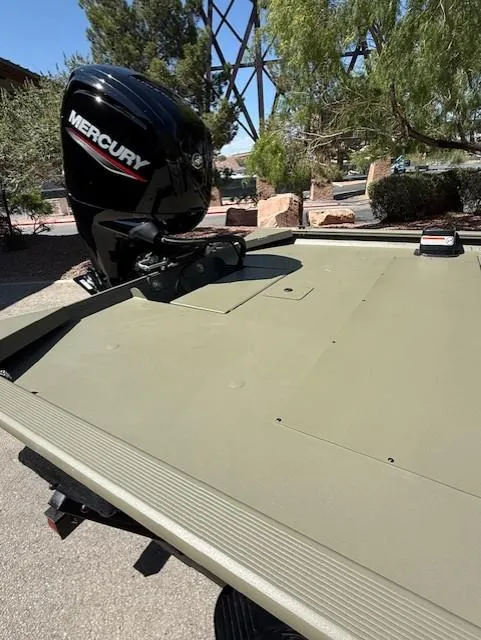 Slide: The Image of 2025 Tracker Grizzly 1860 CC boat with Mercury outboard motor in outdoor setting. - 8