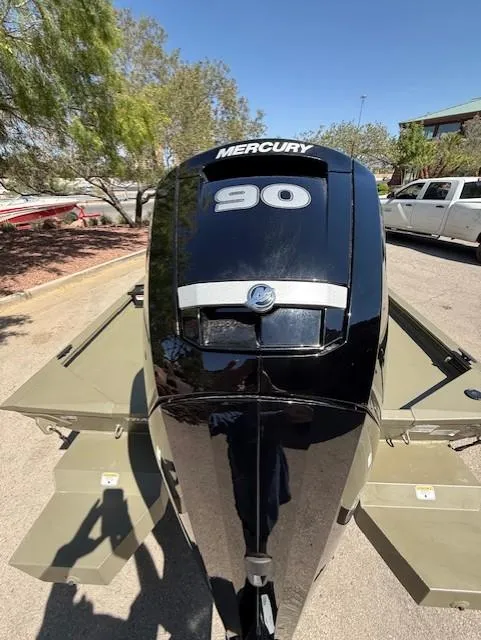 Slide: The Image of 2025 Tracker Grizzly 1860 CC with Mercury 90 engine, parked outdoors. - 9