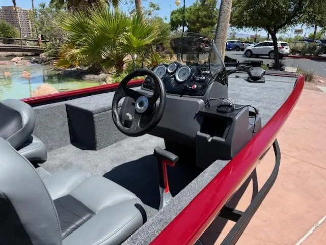 Slide: The Image of 2025 Tracker Pro 170 boat interior with steering console and seating, parked outdoors. - 3
