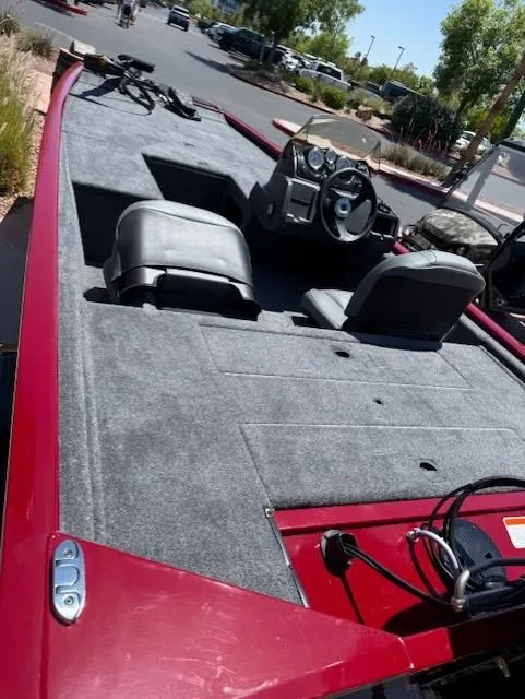 Slide: The Image of 2025 Tracker Pro 170 boat with red exterior and dual seating, parked outdoors. - 5