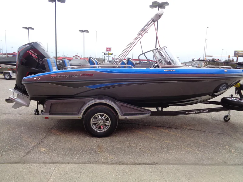 Slide: The Image of 2025 Ranger 1850MS boat on trailer, blue and black design, parked outdoors. - 4