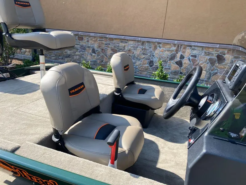 Slide: The Image of 2025 Tracker Bass Tracker Classic Limited boat interior with beige seats and steering console. - 4