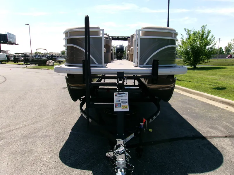 Slide: The Image of 2025 Sun Tracker Party Barge 22 DLX pontoon boat on trailer in parking lot. - 3
