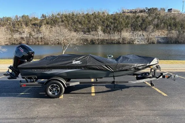 Slide: The Image of 2025 Ranger RT188P boat covered, parked by a scenic river with trees in the background. - 95