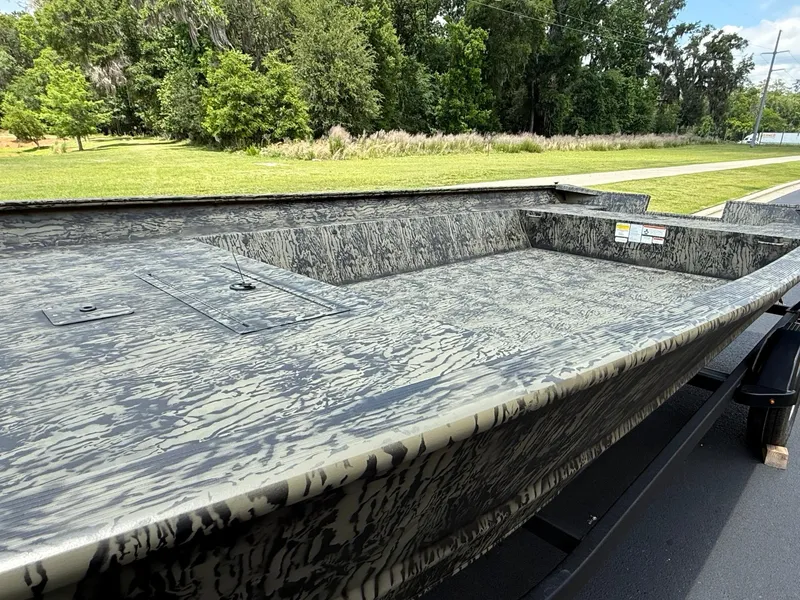 Slide: The Image of 2025 Tracker GRIZZLY 2072 Utility boat with camouflage design on a trailer, surrounded by greenery. - 3