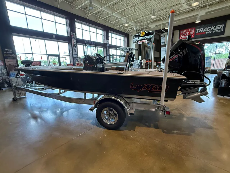 Slide: The Image of 2025 Mako 18 Pro Skiff Backwater Edition displayed indoors on a trailer. - 1