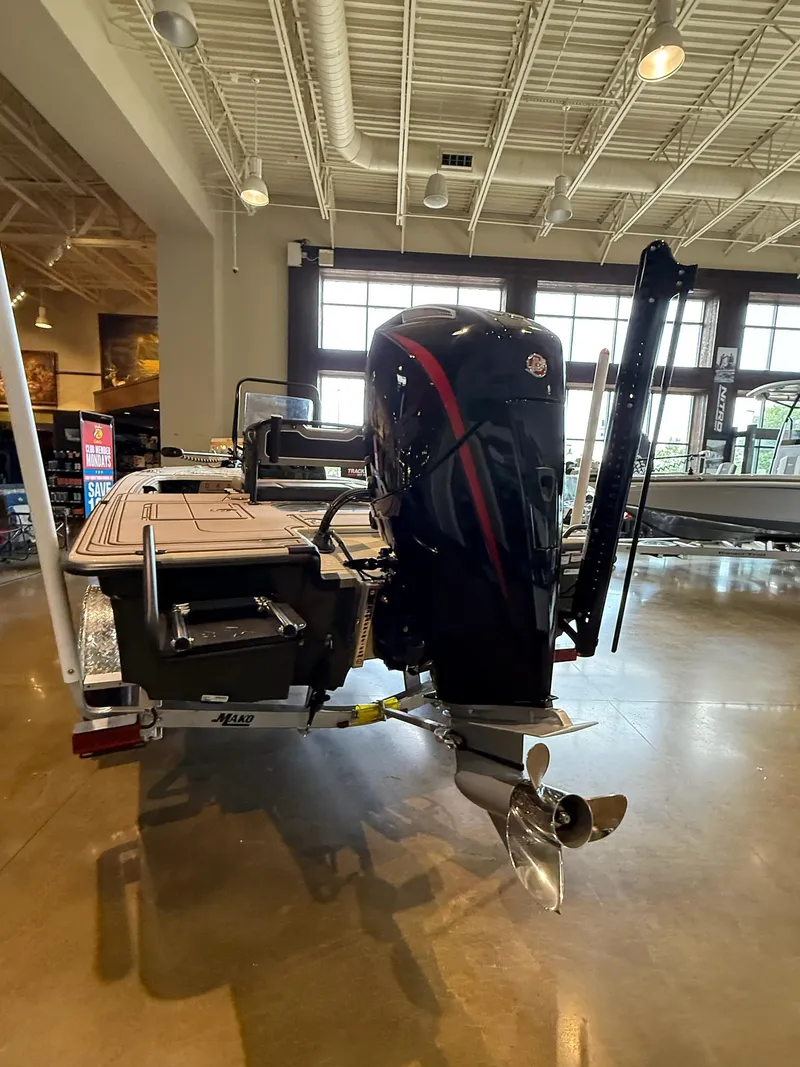 Slide: The Image of 2025 Mako 18 Pro Skiff Backwater Edition in showroom, rear view with motor and propeller. - 2