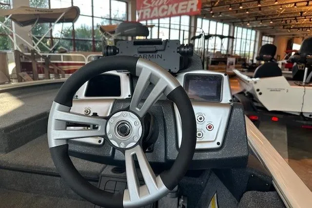 Slide: The Image of 2025 Tracker Savage 215 boat dashboard with steering wheel and Garmin navigation system. - 4