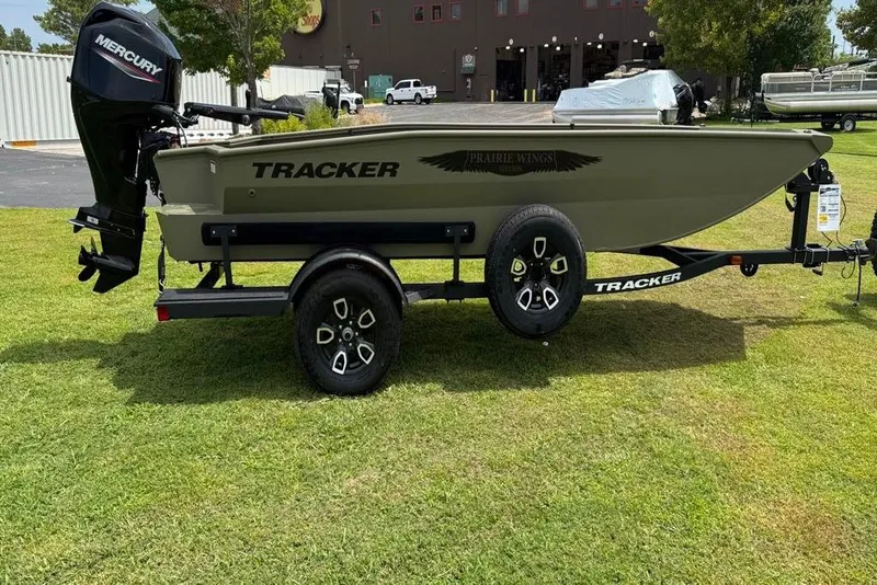 Slide: The Image of 2025 Tracker Grizzly 1650 T Prairie Wings Edition boat on trailer, parked on grass. - 5
