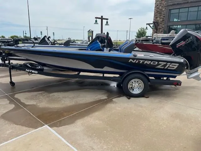 Slide: The Image of 2025 Nitro Z19 boat on trailer, parked outdoors, showcasing sleek design and modern features. - 0
