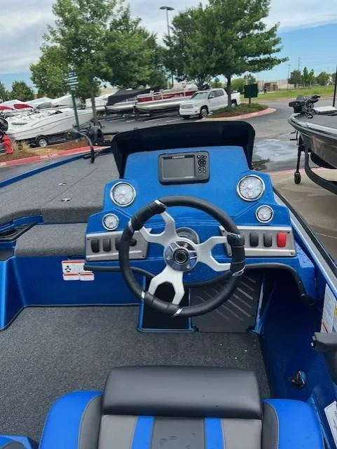 Slide: The Image of 2025 Nitro Z19 boat dashboard with steering wheel and control panel in a marina setting. - 5