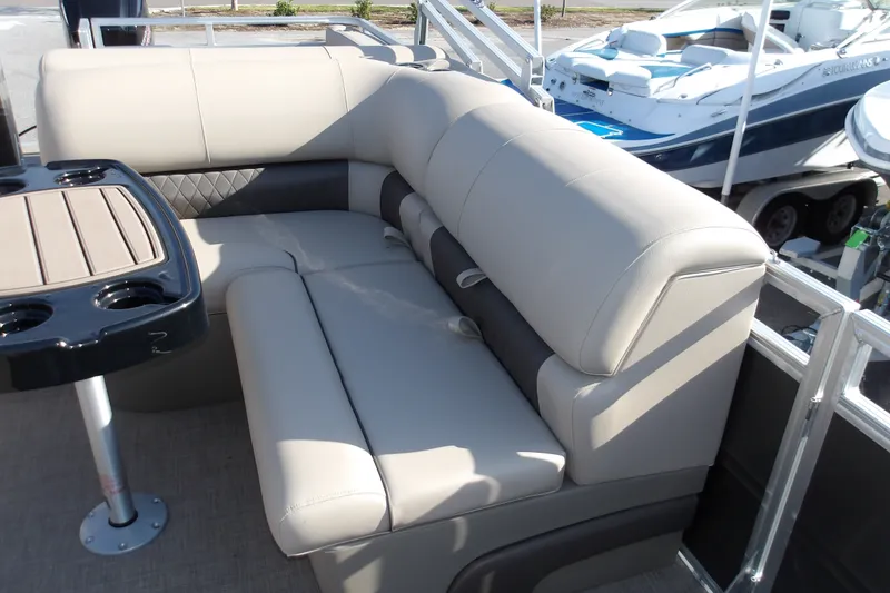Slide: The Image of 2025 Sun Tracker Party Barge 22 RF DLX interior with plush seating and table. - 14