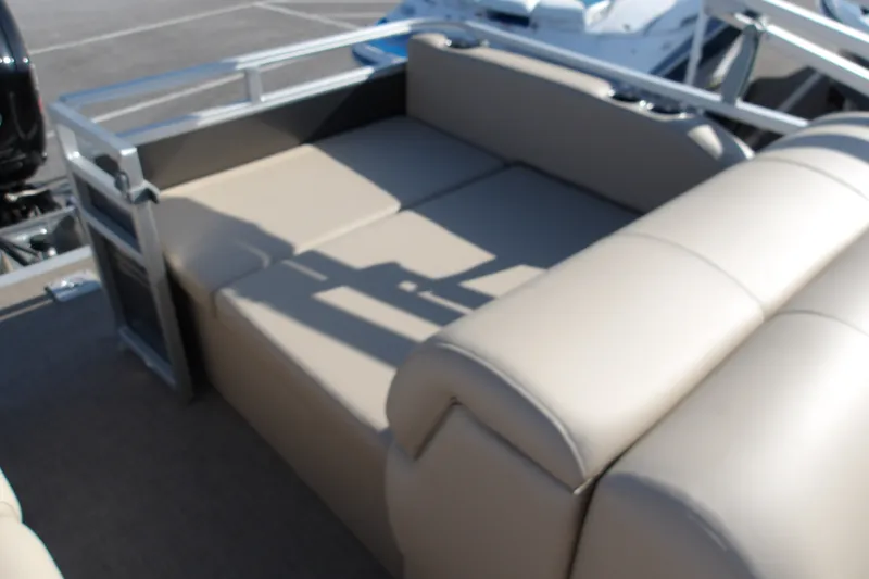 Slide: The Image of 2025 Sun Tracker Party Barge 22 RF DLX with beige seating in a parking lot. - 16