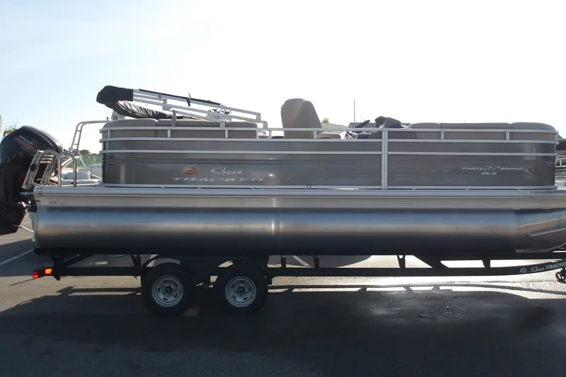 The Image of 2025 Sun Tracker Party Barge 22 RF DLX pontoon boat on trailer, side view. - 1