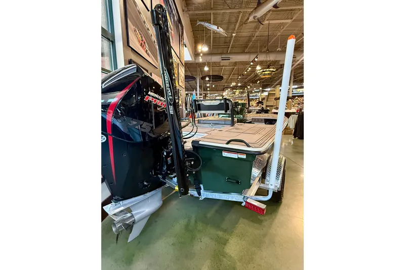 Slide: The Image of 2025 Mako 18 Pro Skiff Backwater Edition with Mercury engine displayed indoors. - 2