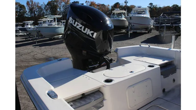 Slide: The Image of 2025 Carolina Skiff 21 LS boat with Suzuki outboard motor, docked among other boats. - 3