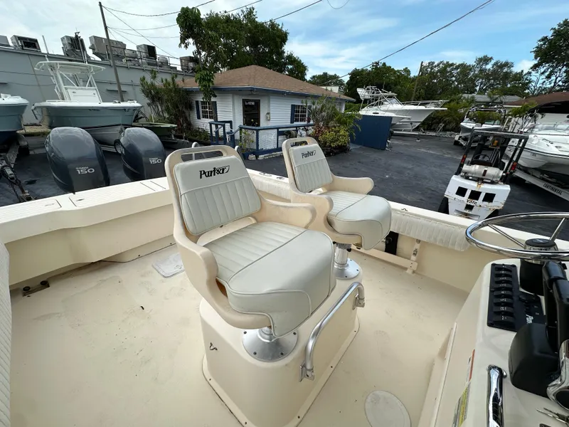 Slide: The Image of Two Parker 25 boat seats on deck, surrounded by boats and equipment, 2011 model. - 12