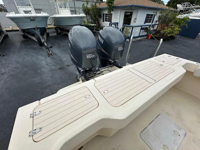 Slide: The Image of Twin Yamaha 150 outboard motors on a 2011 Parker 25 boat, docked near other vessels. - 13
