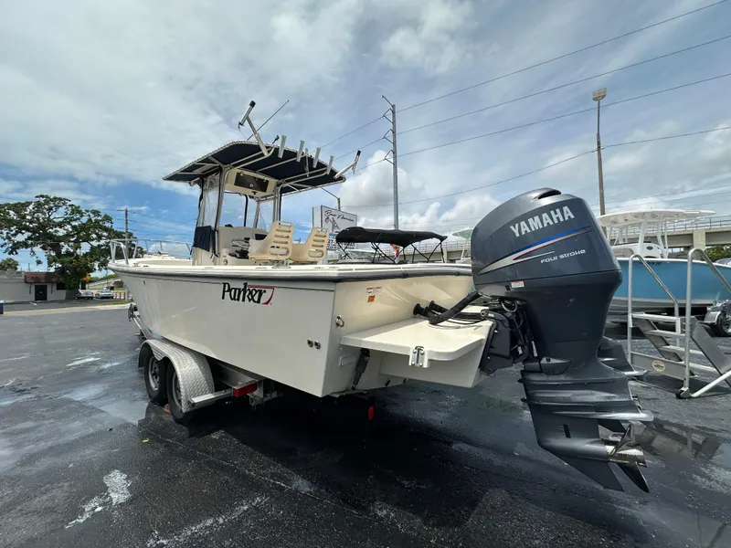 Slide: The Image of 2011 Parker 25 boat with Yamaha outboard motor on a trailer, parked outdoors. - 5
