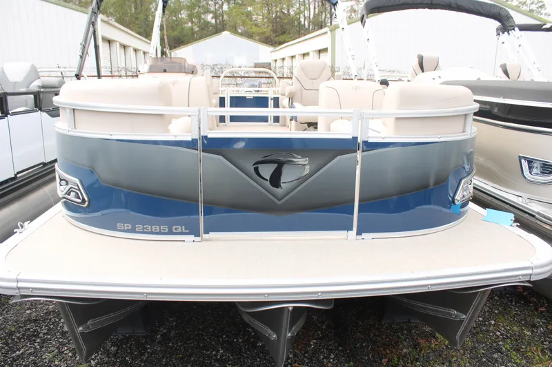 Slide: The Image of 2024 Tahoe Pontoon Sport 2385 QL, blue exterior, docked in a marina setting. - 2