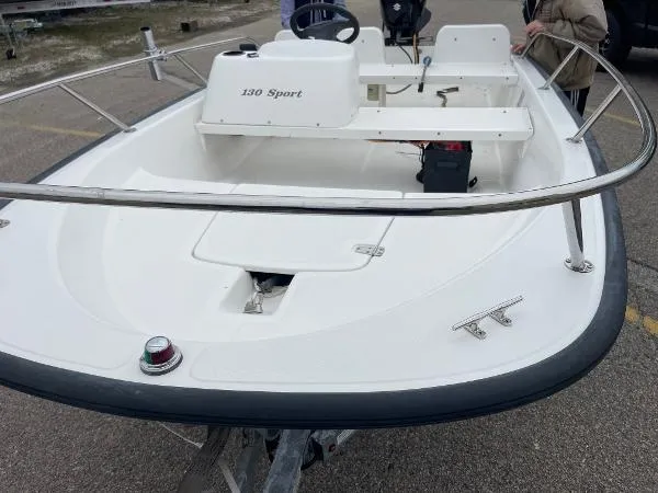 Slide: The Image of 2005 Boston Whaler 130 Sport boat, white deck, stainless steel railings, parked on trailer. - 10