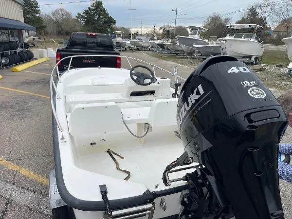 Slide: The Image of 2005 Boston Whaler 130 Sport boat with Suzuki 40 HP engine, parked near a truck. - 4