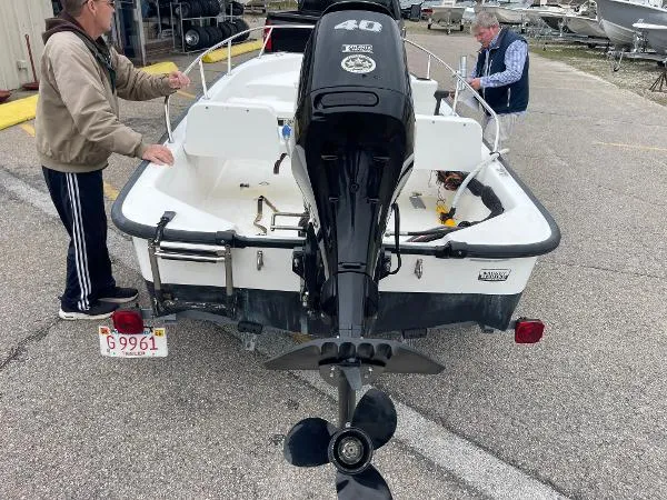 Slide: The Image of 2005 Boston Whaler 130 Sport boat with outboard motor, parked on a trailer. - 6