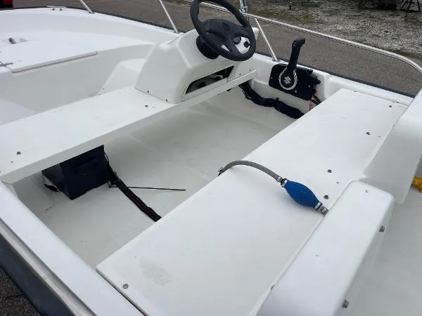 Slide: The Image of 2005 Boston Whaler 130 Sport boat interior with steering wheel and seating. - 7