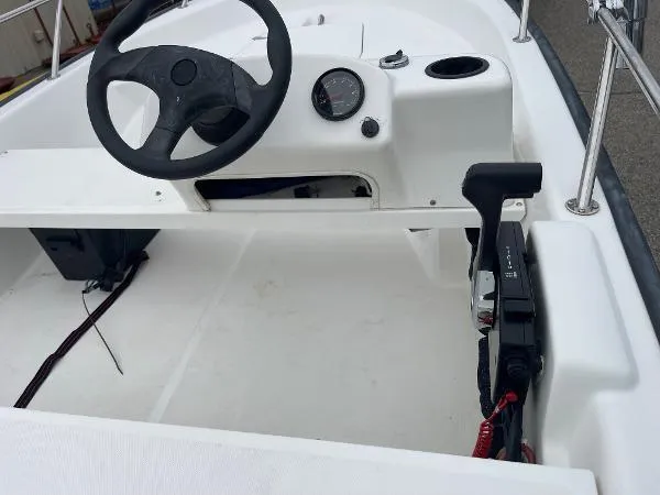 Slide: The Image of 2005 Boston Whaler 130 Sport boat interior with steering wheel and control panel. - 8