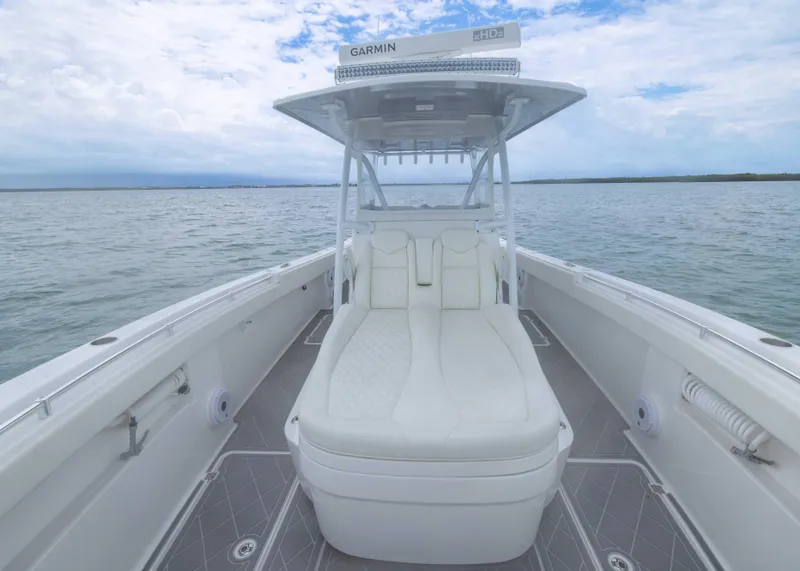 Slide: The Image of 2023 Invincible 33 Catamaran with cushioned seating, open water view, and Garmin equipment. - 17