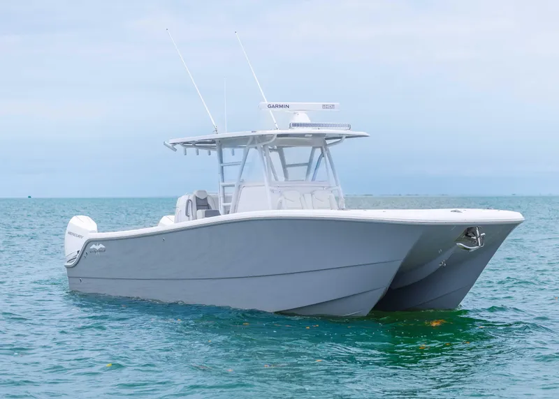 Slide: The Image of 2023 Invincible 33 Catamaran on calm ocean waters, showcasing sleek design and advanced features. - 2