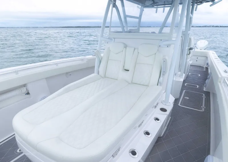 Slide: The Image of 2023 Invincible 33 Catamaran with luxurious white seating on open water. - 23