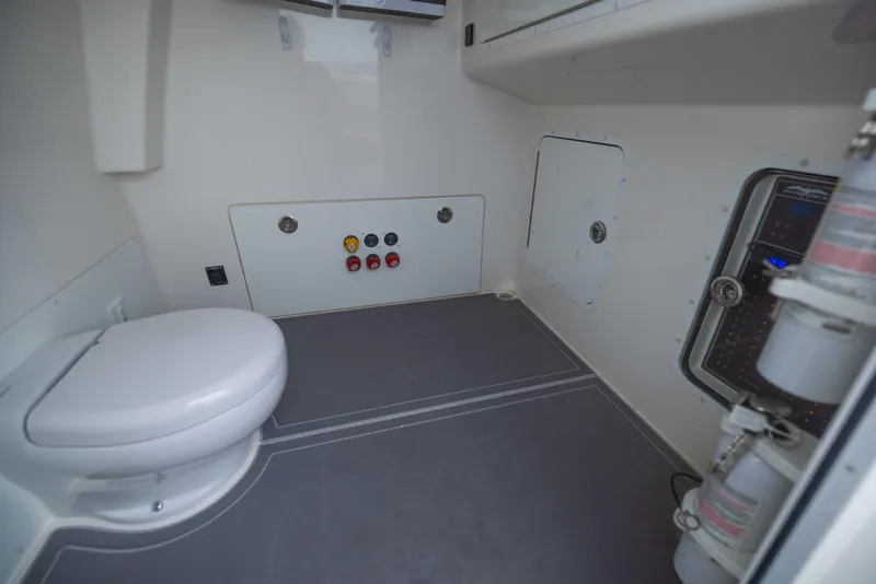 Slide: The Image of 2023 Invincible 33 Catamaran interior with toilet and control panel, showcasing modern marine design. - 25