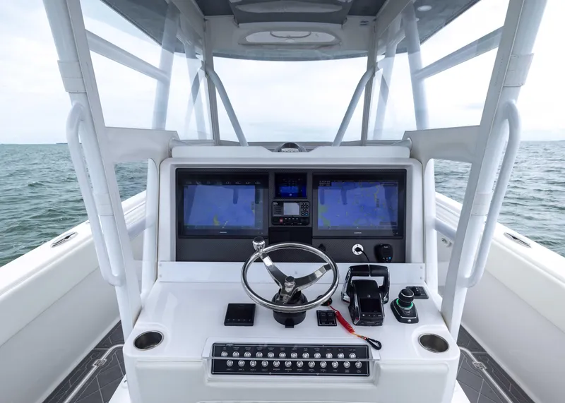 Slide: The Image of 2023 Invincible 33 Catamaran helm with dual navigation screens on open water. - 26