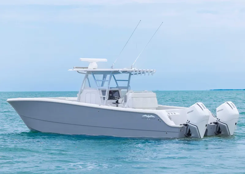 Slide: The Image of 2023 Invincible 33 Catamaran on calm ocean waters, featuring dual outboard engines. - 3