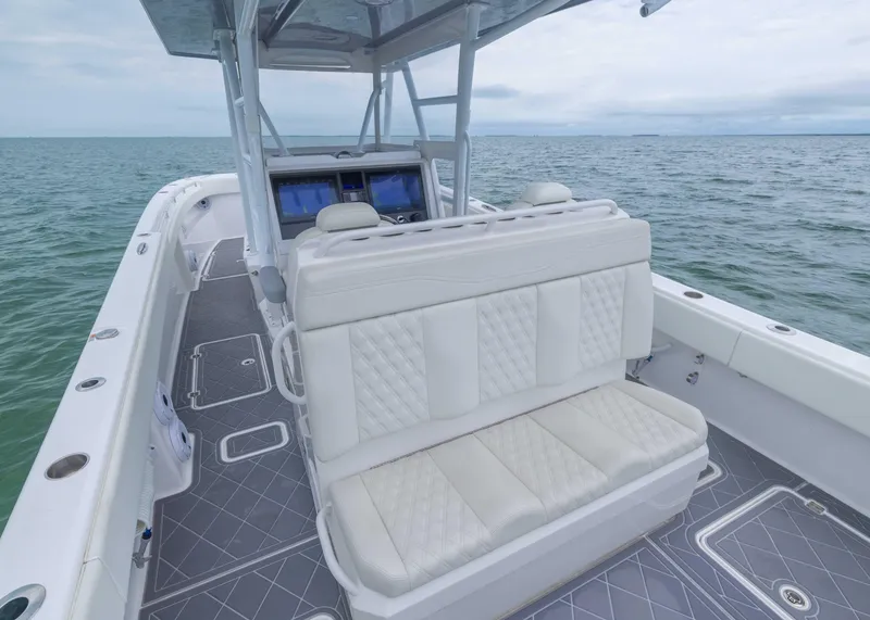 Slide: The Image of 2023 Invincible 33 Catamaran with white seating, sleek design, and ocean backdrop. - 31