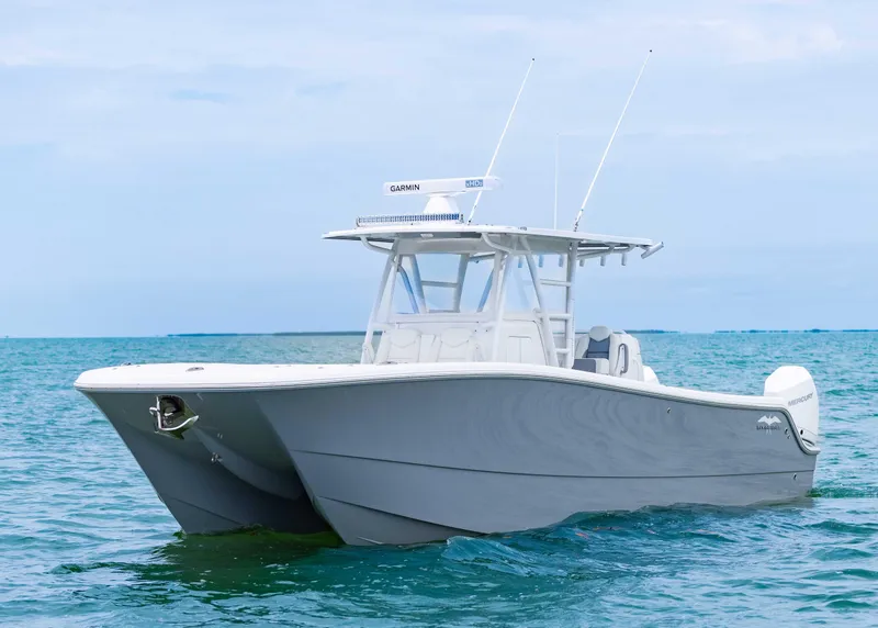 Slide: The Image of 2023 Invincible 33 Catamaran on calm ocean waters, showcasing sleek design and modern features. - 4