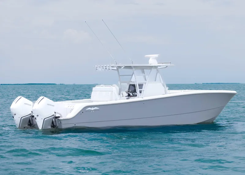 Slide: The Image of 2023 Invincible 33 Catamaran on calm ocean waters, showcasing sleek design and twin engines. - 6