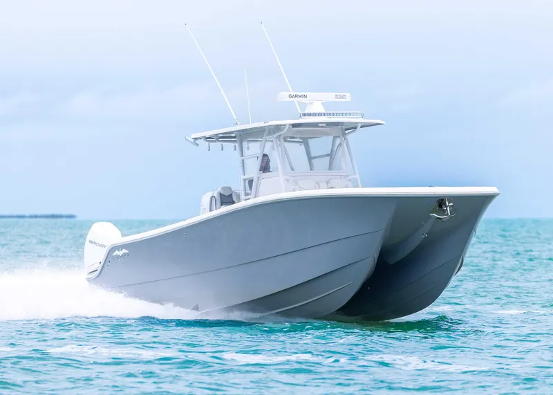 Slide: The Image of 2023 Invincible 33 Catamaran cruising on open water, showcasing sleek design and performance. - 9