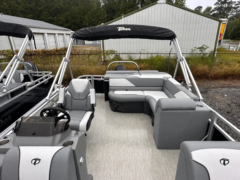 Slide: The Image of 2024 Tahoe Pontoon Sport Cruise boat with gray seating and canopy, parked outdoors. - 10
