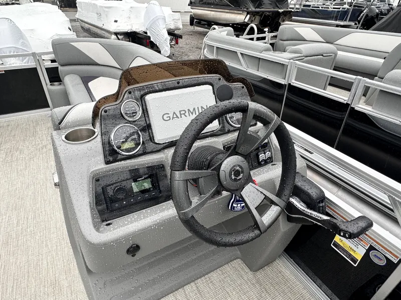 Slide: The Image of 2024 Tahoe Pontoon Sport Cruise dashboard with Garmin navigation and steering wheel. - 12