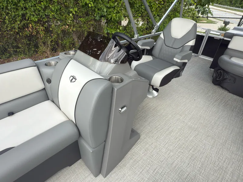 Slide: The Image of 2024 Tahoe Pontoon Sport Cruise interior with gray and white seating and steering console. - 2