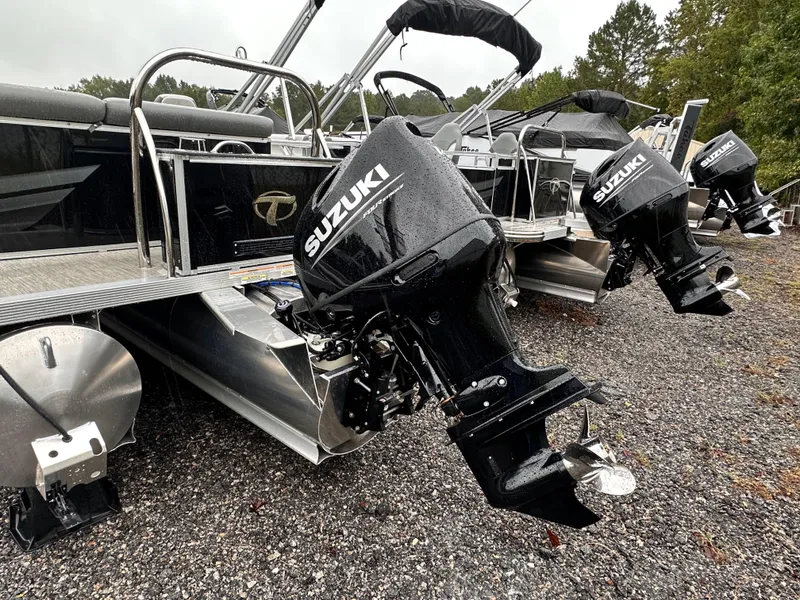 Slide: The Image of 2024 Tahoe Pontoon Sport Cruise with Suzuki outboard motors on gravel surface. - 7