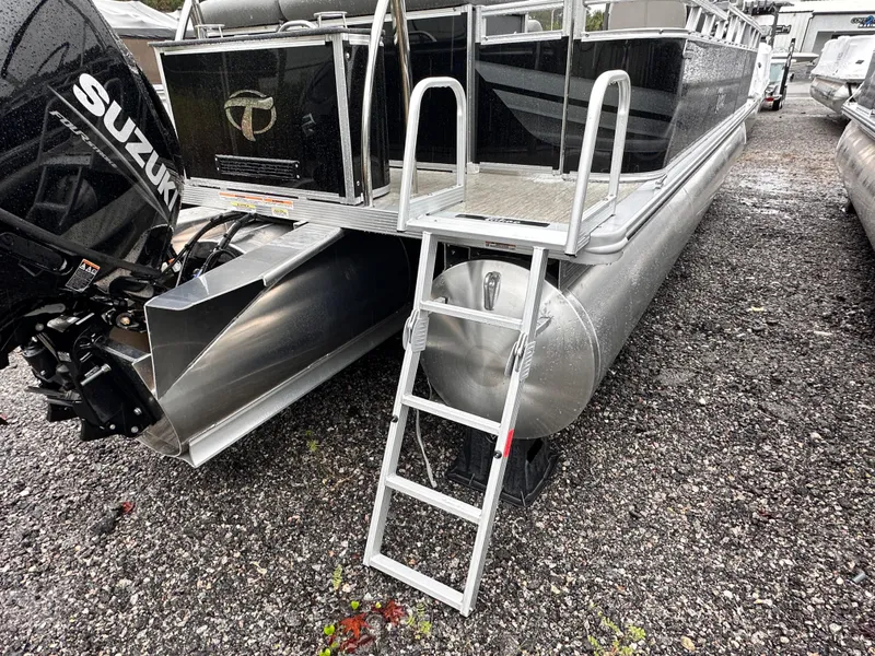 Slide: The Image of 2024 Tahoe Pontoon Sport Cruise with Suzuki engine and ladder on gravel surface. - 9