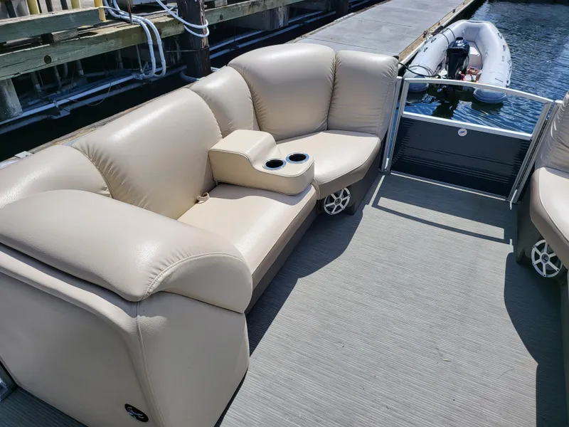 Slide: The Image of 2017 Godfrey Sweetwater 215c pontoon boat with beige seating and cup holders at a dock. - 11