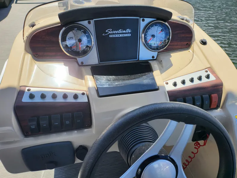 Slide: The Image of 2017 Godfrey Sweetwater 215c boat dashboard with gauges and steering wheel. - 15