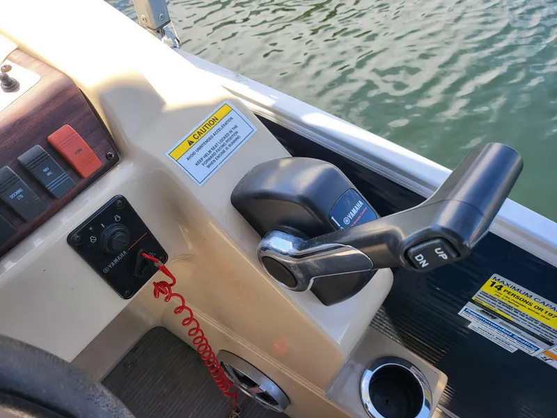 Slide: The Image of Control panel of a 2017 Godfrey Sweetwater 215c boat with throttle and safety features. - 16